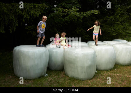 Gruppe von Kindern spielen auf Strohballen sieht aus wie riesige Zähne, Sommerzeit Stockfoto