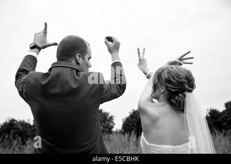 Brautpaare, die Schreibweise des Wortes "Liebe" mit ihren Fingern Stockfoto