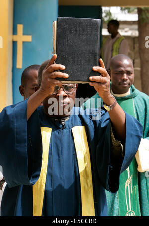 Römisch-katholischer Priester hält Bibel im sonntäglichen Gottesdienst in Maiduguri, Nigeria Stockfoto