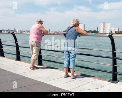 ein älteres Paar mit Blick auf das Meer durch den Hafen von portsmouth Stockfoto