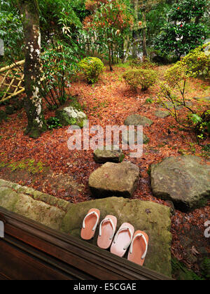 Geta Schuhe draußen ein Ryokan Zimmer mit einem japanischen Garten nach einem Regen. Gero, Japan. Stockfoto