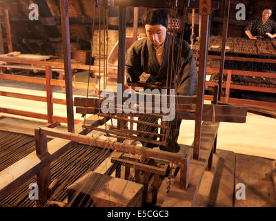 Japanische Textilarbeiterin an eine antike Spinner-Maschine. Museum Anzeige, Gero Onsen Gassho Dorf, Präfektur Gifu, Japan. Stockfoto