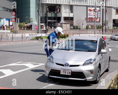 Polizist einen Führerschein des Fahrers in einem Auto nicht mehr überprüfen. Tokio, Japan. Stockfoto