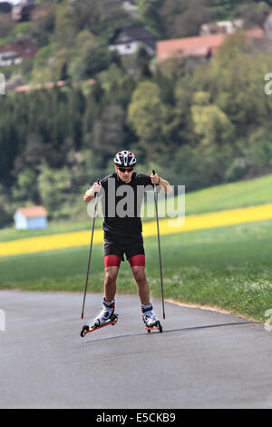 Ein junger Mann-Langlauf mit Roller ski Stockfoto