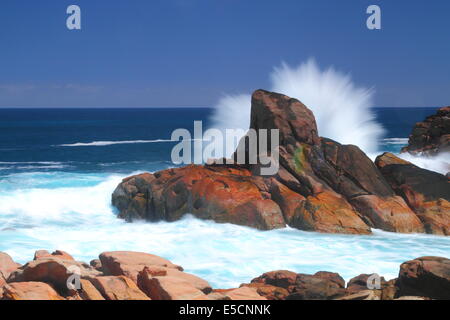 Ein Indischer Ozean Dünung knallt gegen einen Felsen verursacht Spray, entlang der Küste von Western Australia zu zerstreuen. Stockfoto