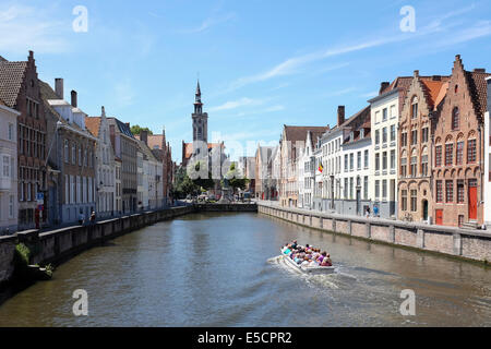 Touristen auf einem Boot Reise auf dem Kanal von Brügge, Belgien. Das alte Zollhaus im Hintergrund. Stockfoto