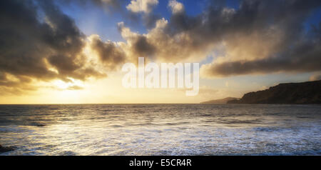 Atemberaubende Landschaft Meer bei Sonnenuntergang dramatische Wolken Stockfoto