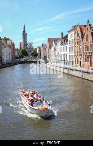 Touristen auf einem Boot Reise auf dem Kanal von Brügge, Belgien. Das alte Zollhaus im Hintergrund. Stockfoto