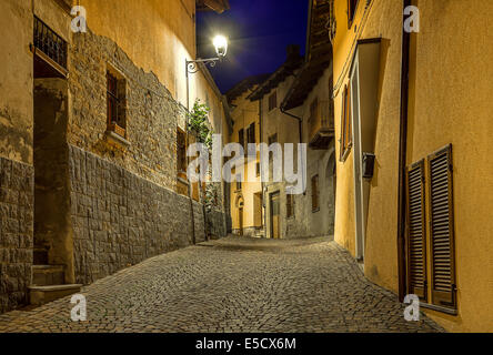 Schmalen gepflasterten Straße zwischen alten Häusern in der Nacht in der Stadt von Barolo, Italien. Stockfoto