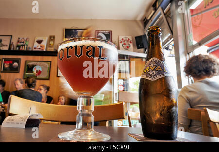 Orval Trappist Belgian Ale-Flasche und Glas auf einem Tisch gegenüber in einem typischen belgischen lokal Stockfoto