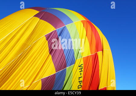 Ein Regenbogen farbige Heißluftballon aufblasen vor einem strahlend blauen Himmel im Avon Valley, Western Australia. Stockfoto