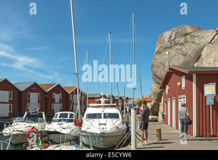 Roten hölzerne Fischerhütten mit Booten entlang Holzmole in der Stadt von Smögen, Bohuslän, Iän Västra Götaland, Schweden, Skandinavien. Stockfoto