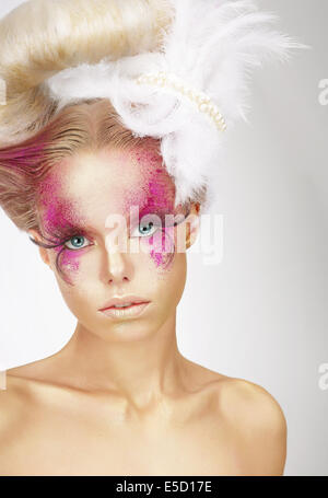 Auffällige Frau mit Fuzzy Federn und fantastische Kunst Make-up Stockfoto