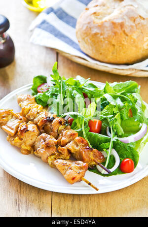 Gegrillter Hühnerspieß mit Rucola-Salat mit Brot Stockfoto