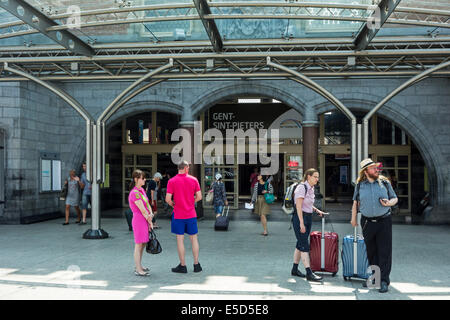 Reisende mit Koffern am Eingang des Gent-Sint-Pieters / Sankt Peter Bahnhof in Gent, Flandern, Belgien Stockfoto