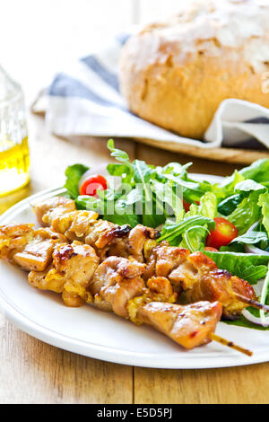 Gegrillter Hühnerspieß mit Rucola-Salat mit Brot Stockfoto