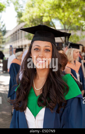 Junge Frau, Absolventin am Abschlusstag, in Kittel und Mörtel Board, UEA ( University of East Anglia ), Norwich, Großbritannien Stockfoto