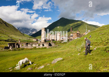 Weißes Pferd und Mensch in Ushguli Hintergrund. Swanetien, Georgia. Ushguli, dem höchstgelegenen ganzjährig bewohnten Dorf in Europa. Svane Stockfoto