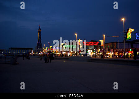 Menschen, die ein Spaziergang entlang der Promenade Blick auf Blackpool Ablichtungen mit dem Turm in der Ferne leuchtet Stockfoto