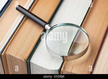 Bücher und Lupe isoliert auf weißem Hintergrund Stockfoto