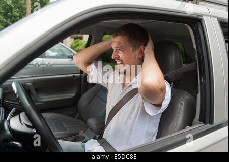 Junger Europäische Fahrer ist schockiert über etwas Stockfoto