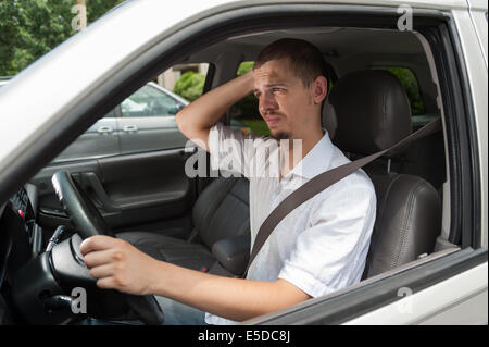 Junger Europäische Fahrer ist über etwas nachdenken. Stockfoto