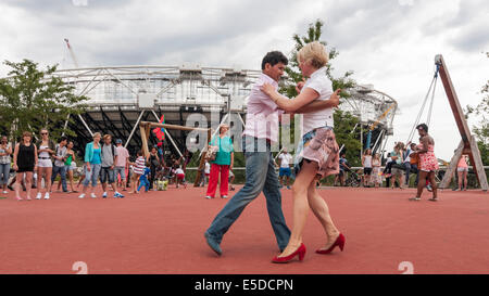 Queen Elizabeth Olympic Park, Stratford, London, UK, 27. Juli 2014.  Der große britische Karneval feiert den zweiten Jahrestag der Eröffnungsfeier der Olympischen Spiele 2012 in London sowie die Kennzeichnung der Halbzeit zwischen der London und die Olympischen Spiele in Rio.  Es gab Pop-up-Paraden mit Musik, Kostüme und Samba. Im Bild: spontane Salsa-Tanz von den Besuchern.  Bildnachweis: Stephen Chung/Alamy Live-Nachrichten Stockfoto