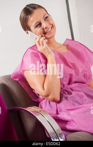 Frau des Patienten in das Handy im Krankenhaus Wartezimmer anlässlich der 40er Jahre. Stockfoto