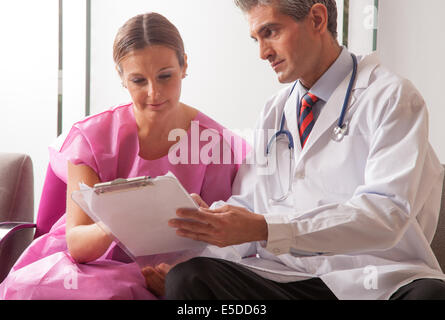 Männlichen Arzt medizinische Untersuchungen zu seiner geduldigen Frau zeigen. Stockfoto