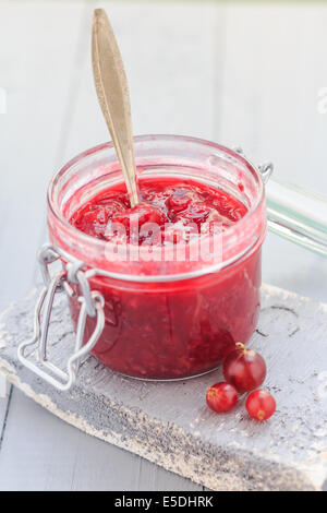 Offenen Glas Stachelbeeren Marmelade mit einem Löffel in der Mitte Stockfoto