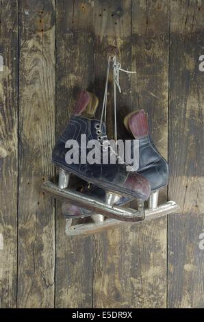 alten Schlittschuhen auf Hintergrund Holz Stockfoto