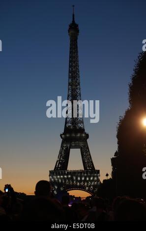 Eiffelturm Paris Sonnenuntergang gegen einen tiefblauen Himmel und roten Wolken, weiße Lichter auf die grau Kunstschmiedearbeiten, Touristen-silhouette Stockfoto