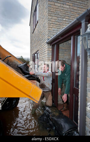 Workman Sandsack ein Haus gegen Hochwasser im Dorf Moorlandschaften auf der Somerset Levels UK Stockfoto