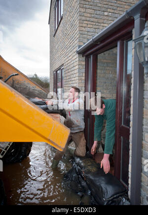 Workman Sandsack ein Haus gegen Hochwasser im Dorf Moorlandschaften auf der Somerset Levels UK Stockfoto