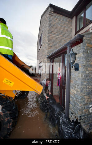 Workman Sandsack ein Haus gegen Hochwasser im Dorf Moorlandschaften auf der Somerset Levels UK Stockfoto