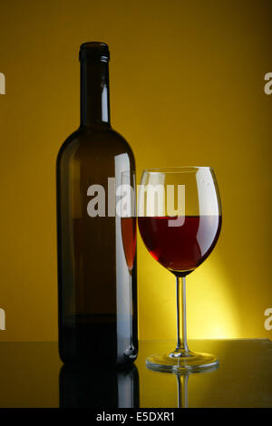 Weinglas und eine Flasche Rotwein mit Platz für Ihren Text rechts Stockfoto
