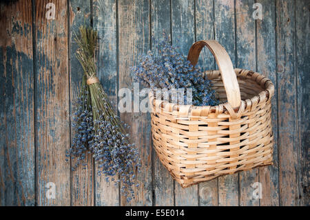 Duft von Lavendel in einem Korb hängt an einer alten Holztür Stockfoto