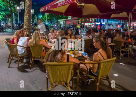 amsterdam, Holland, Niederlande, Junge weibliche Touristen teilen Getränke auf Cafe Terrasse Stadtplatz, Bürgersteig, Stadtstraße bei Nacht, junge Leute, Stockfoto