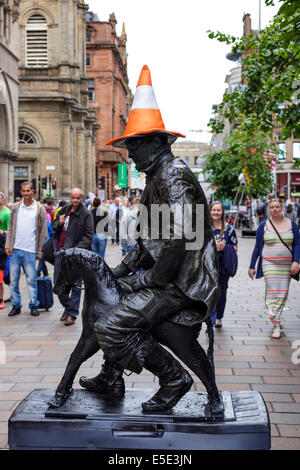 Glasgow, Schottland. 29. Juli 2014. Kevin Powell Street und MIME-Künstler aus Cheshire, England zeigt einige Unternehmertum durch die Nachahmung von Glasgows ikonische Statue des Herzogs von Wellington mit einem Parkplatz Kegel auf den Kopf durch das sitzen auf einem kleinen hölzernen Pferd in Buchanan Street Fußgängerzone. Die Herzog von Wellington Statue ist ein erkennbares Symbol Glasgow Humor und Kevin Powells Spott erstellt eine enorme Menge an Interesse und lachen. Eine lebensgrosse Statue diente während der Eröffnungsfeier der Commonwealth Games. Bildnachweis: Findlay/Alamy Live-Nachrichten Stockfoto