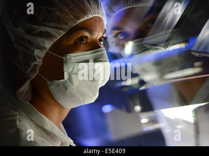 Darmstadt, Deutschland. 25. Juni 2014. Die Fotos von pharmazeutisch-chemische Unternehmen Merck KGaA veröffentlicht zeigt Mitarbeiter Isabel Ribeiro bei der optischen Kontrolle Endstation Merck Pharma Produktion in Darmstadt, Deutschland, 25. Juni 2014. Sechs Kameras untersuchen Concor Betablocker Tabletten und entledigt sich fehlerhafte Tabletten. Foto: ARNE DEDERT/Dpa/Alamy Live-Nachrichten Stockfoto