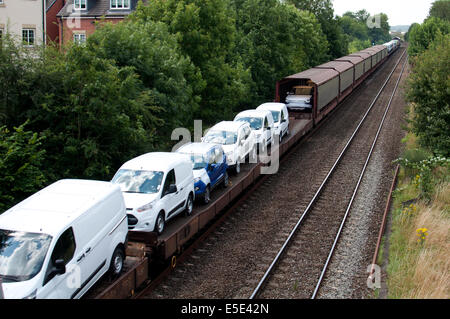 Zug mit neuen Ford Transporter und Pkw Stockfoto