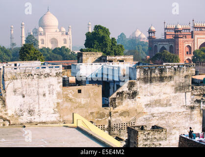 Eine Frau, die Trocknung Sarees auf einem Dach mit dem Taj Mahal in der Ferne, Agra Stockfoto