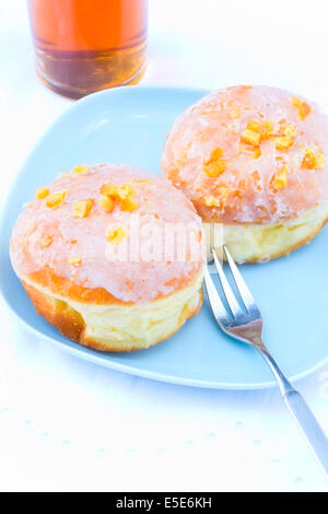 Zwei Zucker glasierte Donuts mit kandierten Orangenschalen. Stockfoto