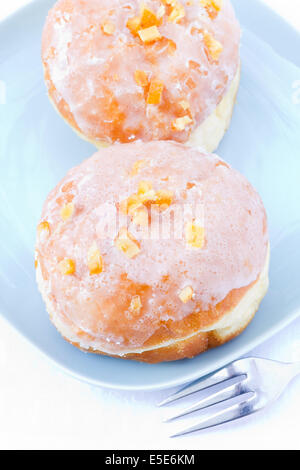 Zwei Zucker glasierte Donuts mit kandierten Orangenschalen. Stockfoto