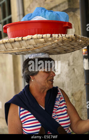 Portugiesische Frau Wäschekorb auf dem Kopf tragen Stockfoto