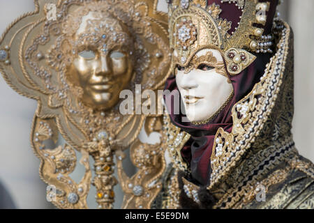 Mann in schwarz und gold aufwendige Karnevalskostüm tragen Leben Größe Maske auf Personal in den Markusplatz, Venedig. Stockfoto