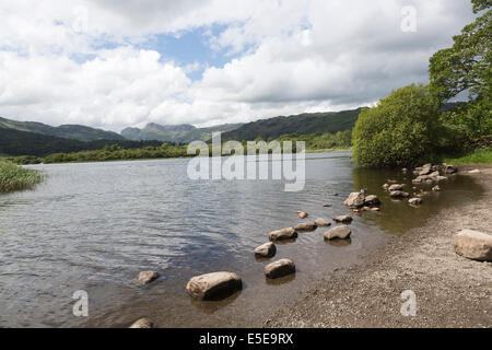 Felsen am Ufer des Sees Elterwater, Lake District, Cumbria, Blick auf die saisonabhängige, blauer Himmel mit Wolken zu sammeln Stockfoto