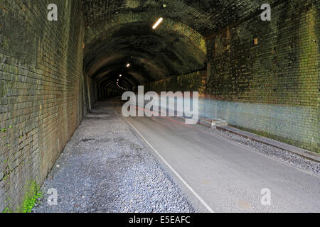 Radfahrer-Bewegungsunschärfe im Litton-Tunnel auf der Monsal Trail, Derbyshire, Peak District National Park, England, UK. Stockfoto