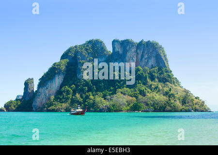 Thai Longtail-Boot vor einer felsigen Insel in der Nähe von Krabi, Thailand Stockfoto