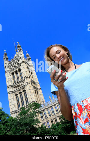 Eine junge Frau mit ihrem Telefon an einem sonnigen Tag Stockfoto